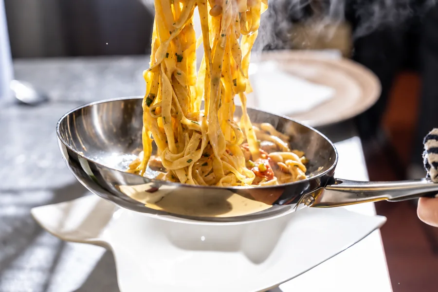 Fresh tagliatelle lifted steaming from the pan at Bella Vista, Bristol